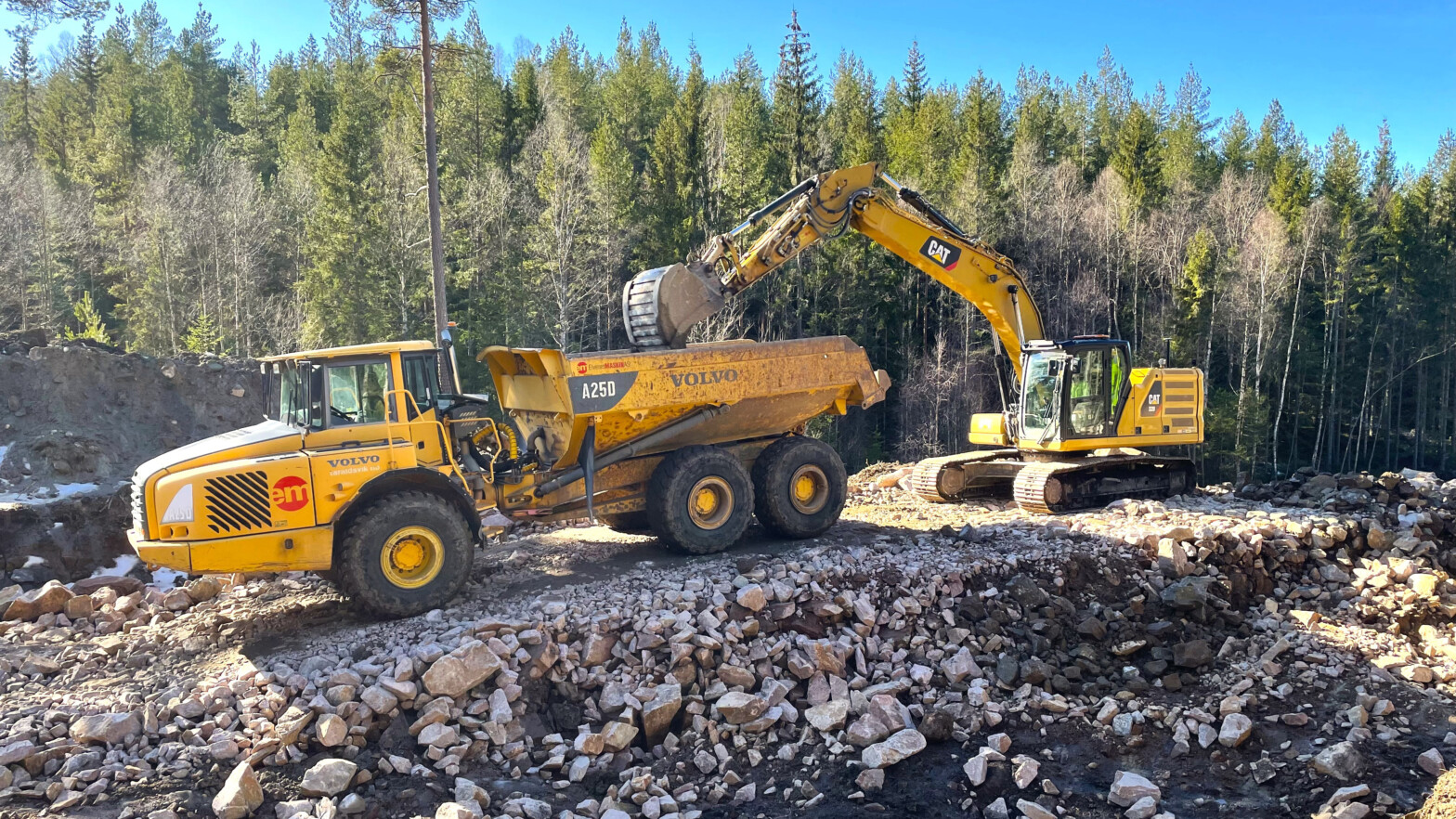 Dumper og en gravemaskin som er i arbeid på en skogsbilveiprosjekt. Foto.