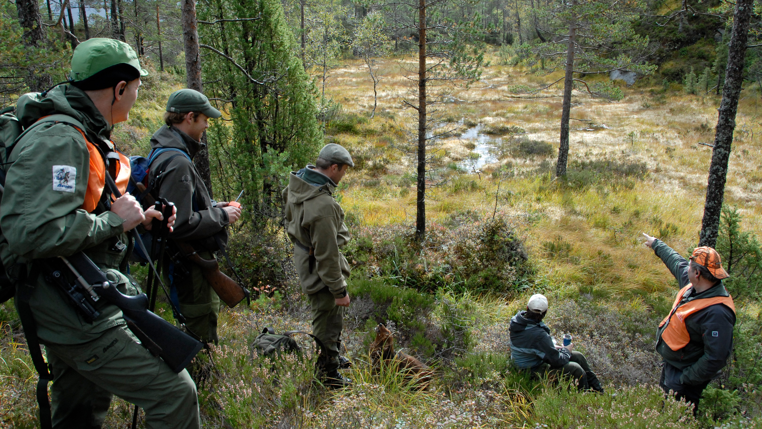 jaktleder som forklarer inngangen til et jaktfelt for en gruppe jegere.